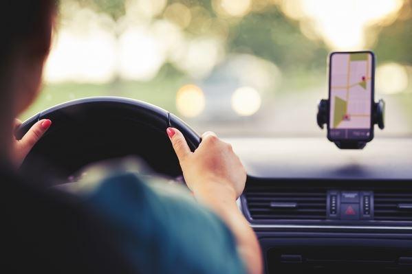 Mulher dirigindo com aplicativo de mapa no celular
