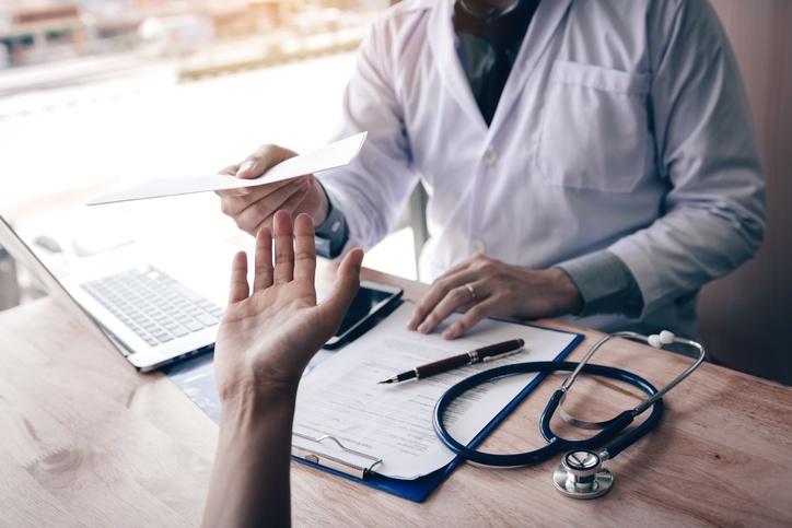 Médico entregando atestado a paciente