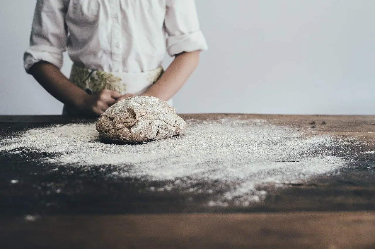 Massa da pão com um padeiro ao fundo